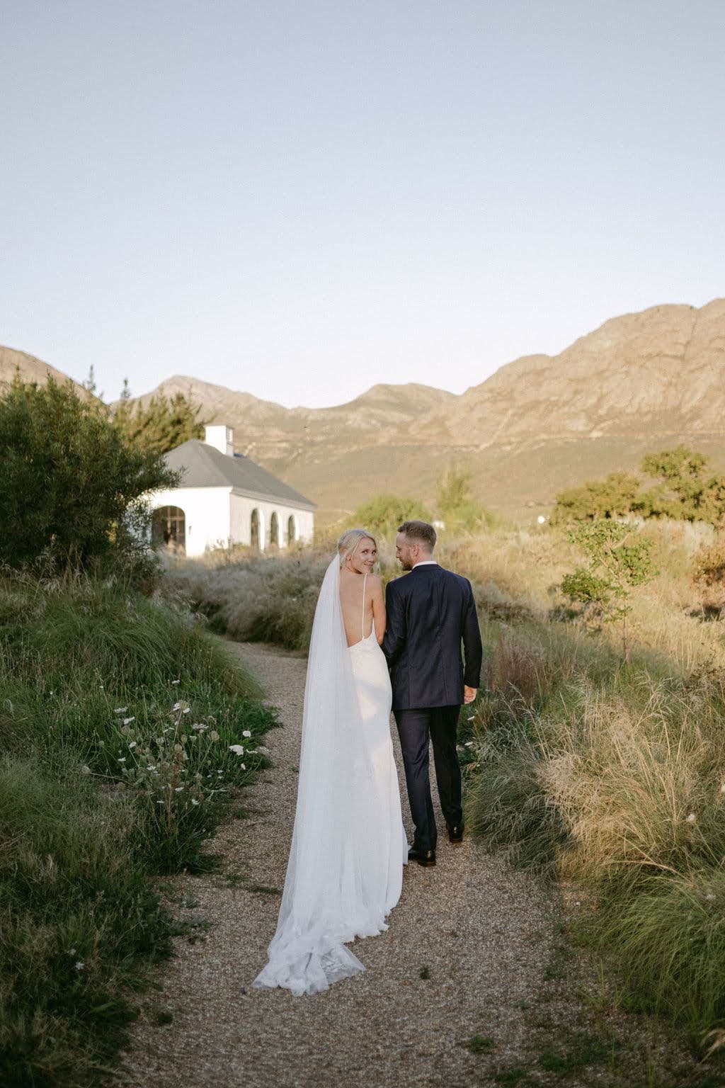 A couple walking together on a path with mountains in the background